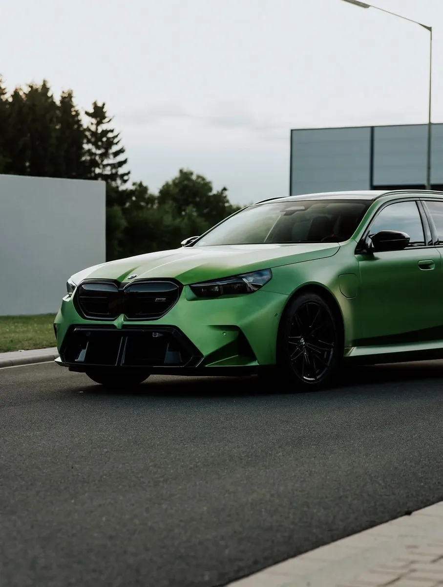 Grüner BMW M5 mit getönten Scheiben vor der madwörx-Werkstatt